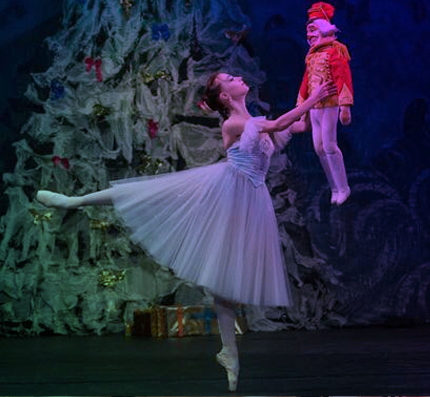 ballerina with long tutu holding a doll