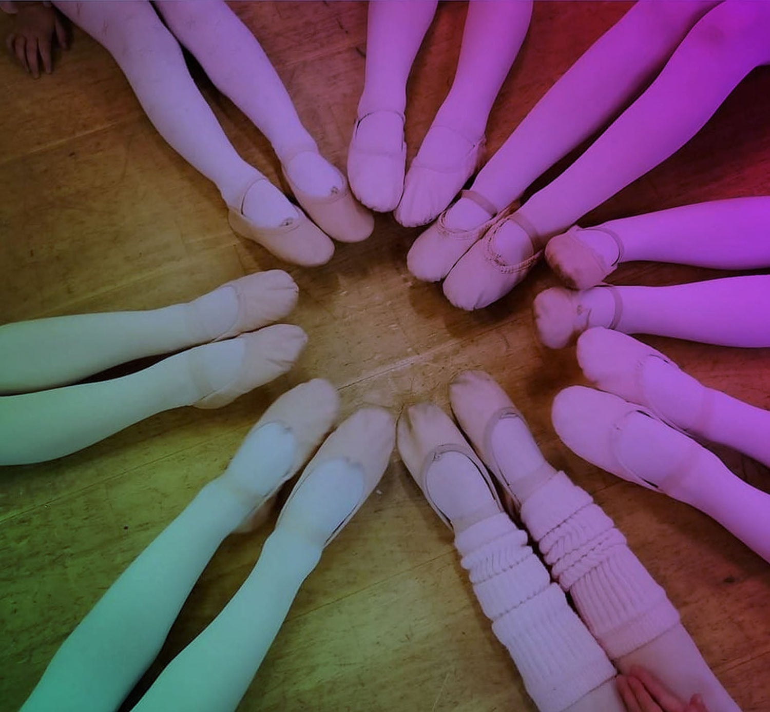 many ballerinas showing their feet with ballet shoes and ballet tights forming a circle