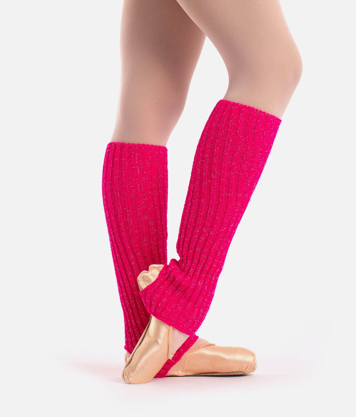 Bright pink ribbed knit leg warmers worn on a dancer's legs, paired with gold ballet slippers against a light gray studio background.
