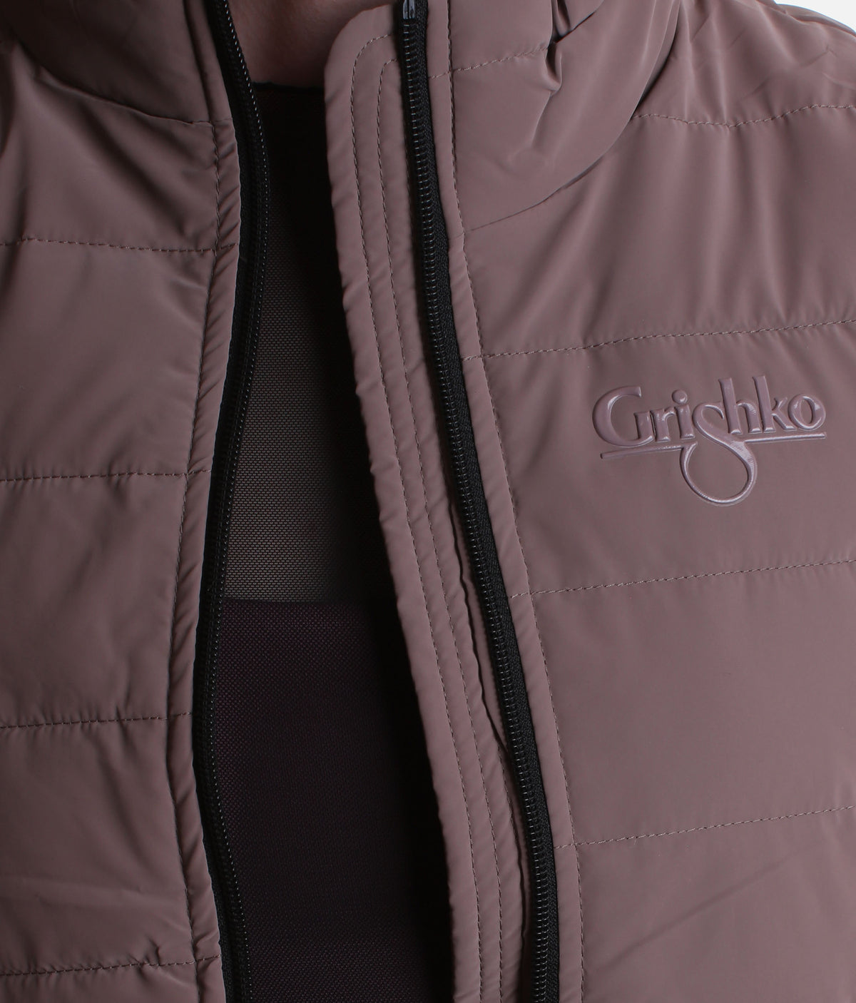 Close-up of a quilted puffer jacket in a muted taupe-brown color, featuring a black zipper and a tonal embroidered 'Grishko' logo on the chest.